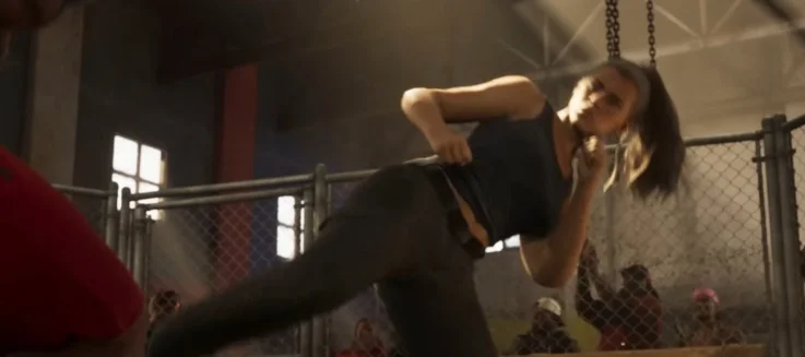 Lucia executing a high kick against an opponent in a fenced fighting arena.