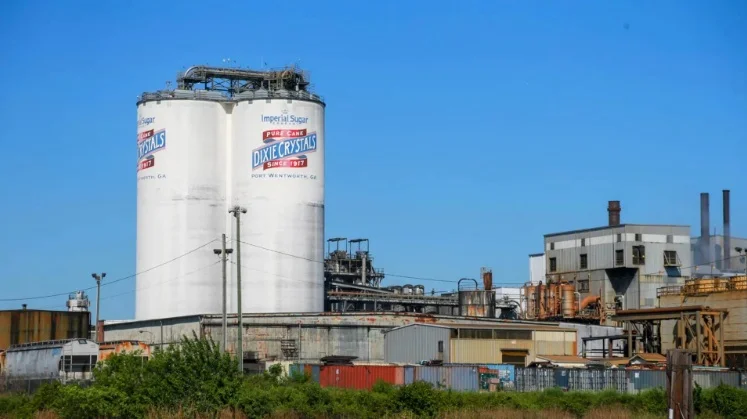 A large industrial facility with smoke rising from chimneys.